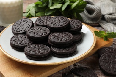 Plate with tasty sandwich cookies on wooden table, closeup