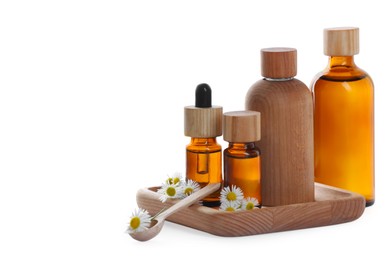 Photo of Bottles of chamomile essential oil and flowers on white background