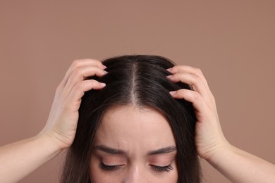 Photo of Woman examining her hair and scalp on beige background, closeup