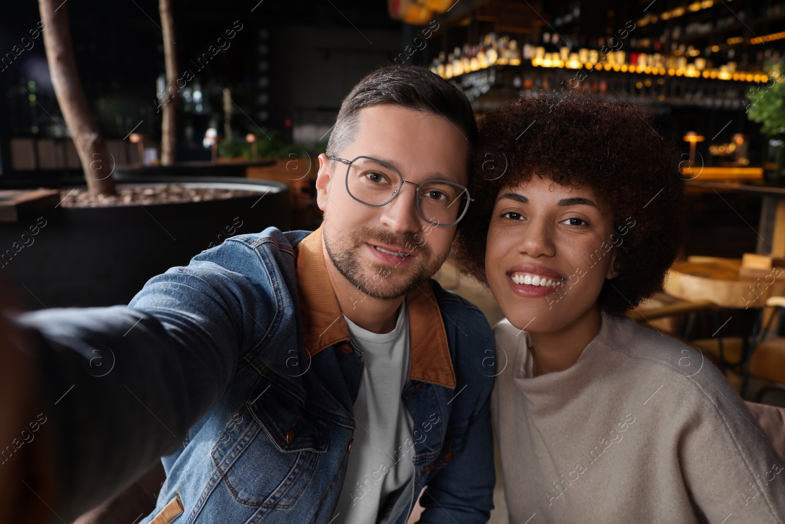 Photo of International dating. Happy couple taking selfie in cafe