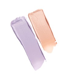 Strokes of pink and purple color correcting concealers on white background, top view