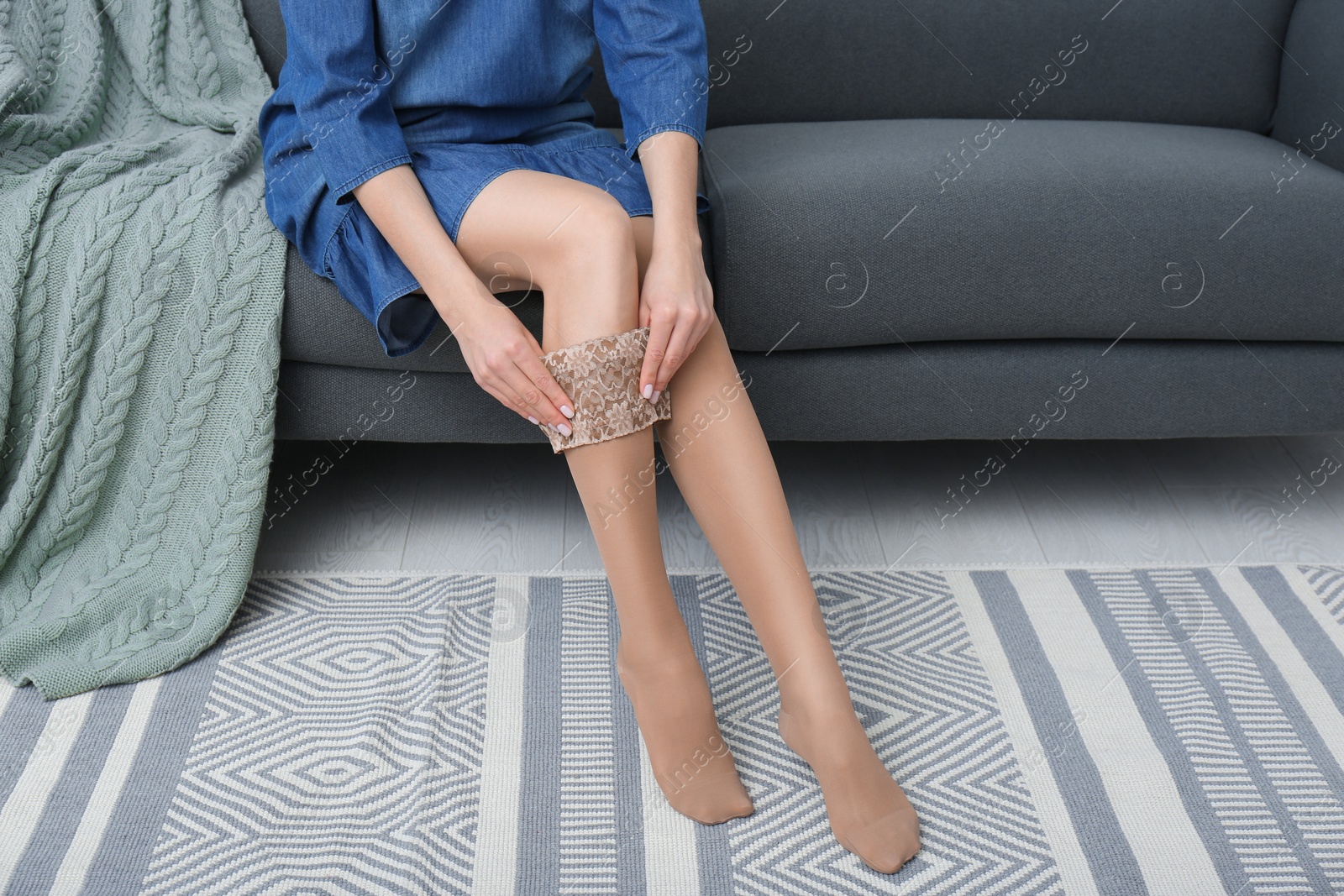 Photo of Woman wearing compression tights in living room, closeup