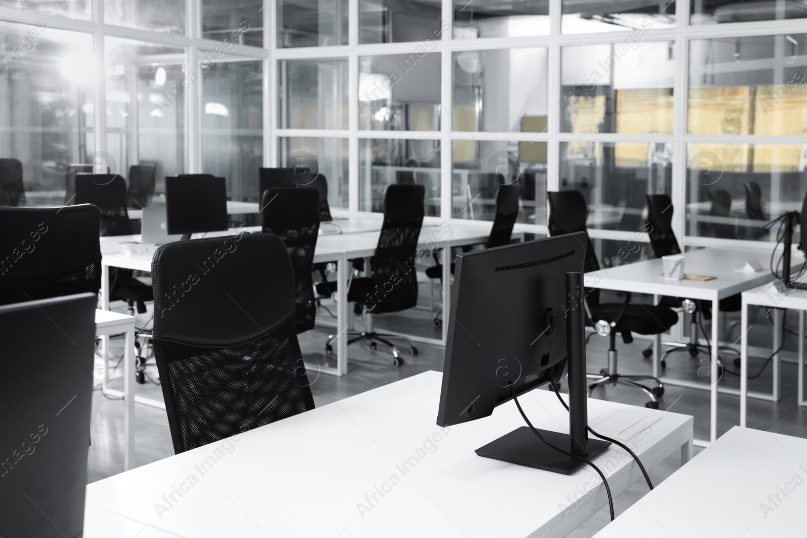 Photo of Stylish interior of open plan office. Workspace with computers, tables and chairs