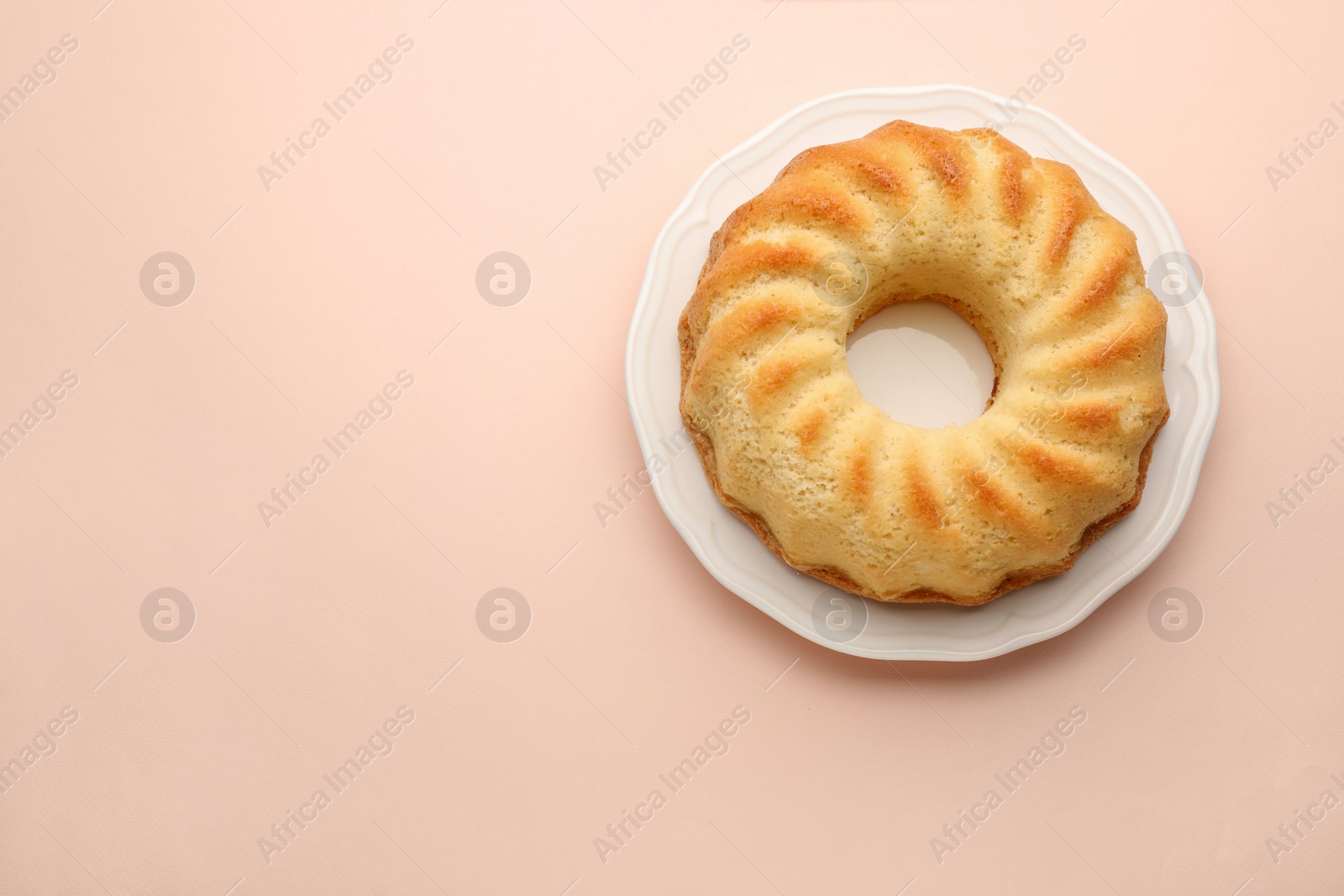 Photo of One tasty sponge cake on beige background, top view. Space for text