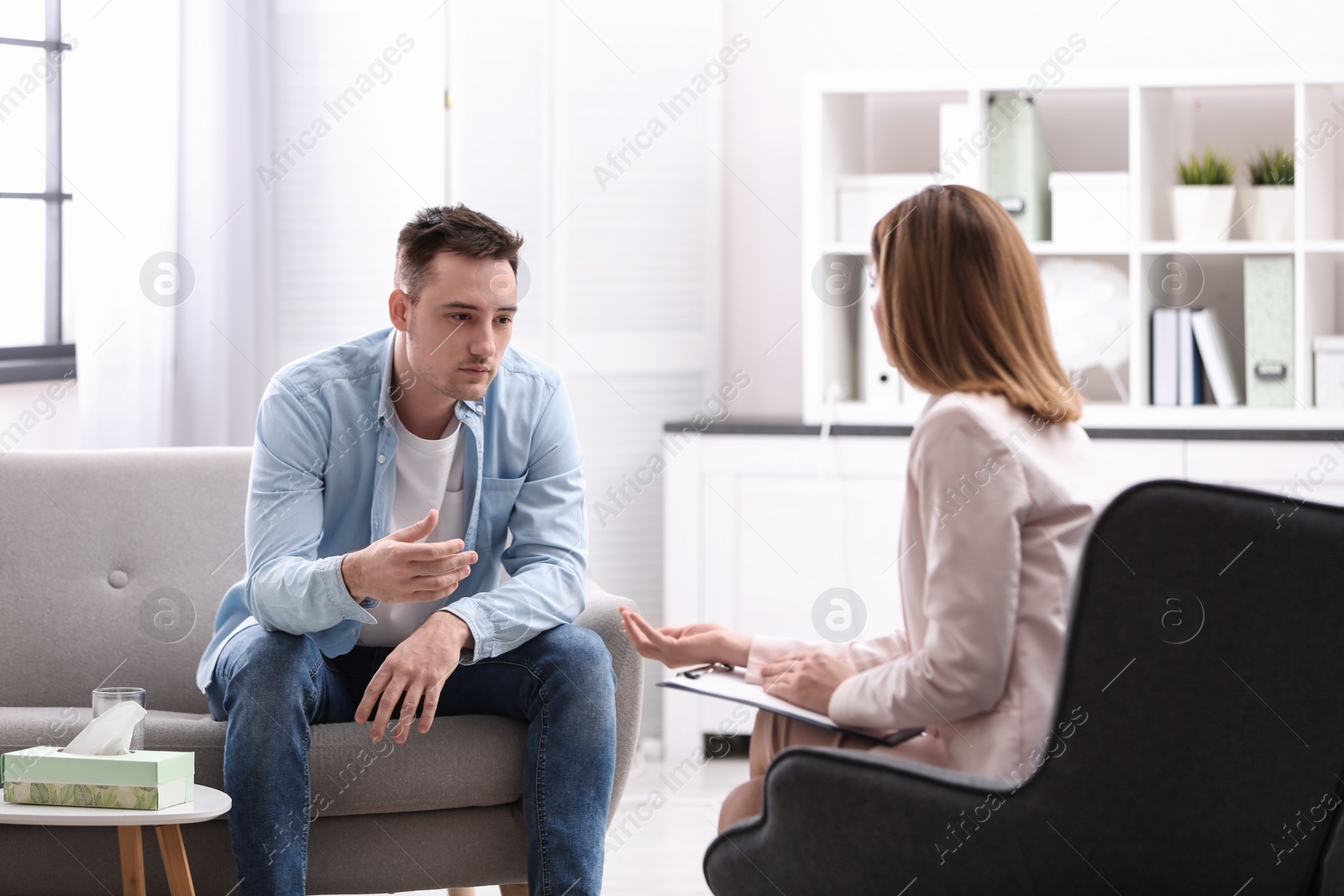 Photo of Psychotherapist working with young man in office