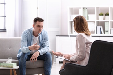 Photo of Psychotherapist working with young man in office