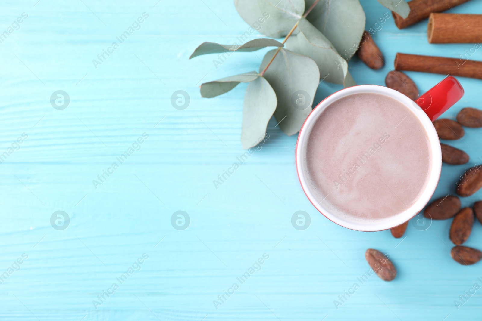 Photo of Flat lay composition with cup of tasty cocoa on blue wooden table. Space for text