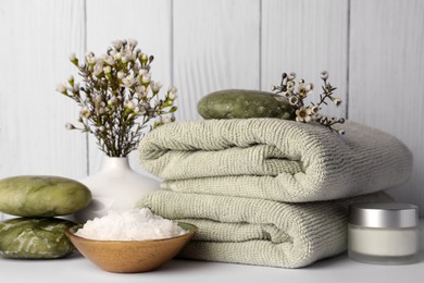 Photo of Composition with different spa products and flowers on white table against wooden background