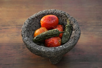 Ingredients for salsa sauce in stone bowl on wooden table