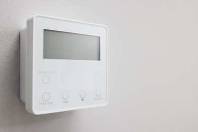 Photo of One thermostat on white wall, closeup and space for text. Smart home system