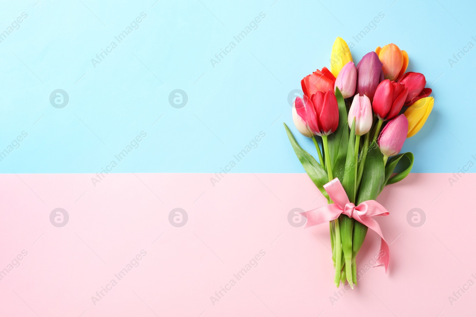 Photo of Beautiful bouquet of spring tulip flowers on color background, top view. Space for text