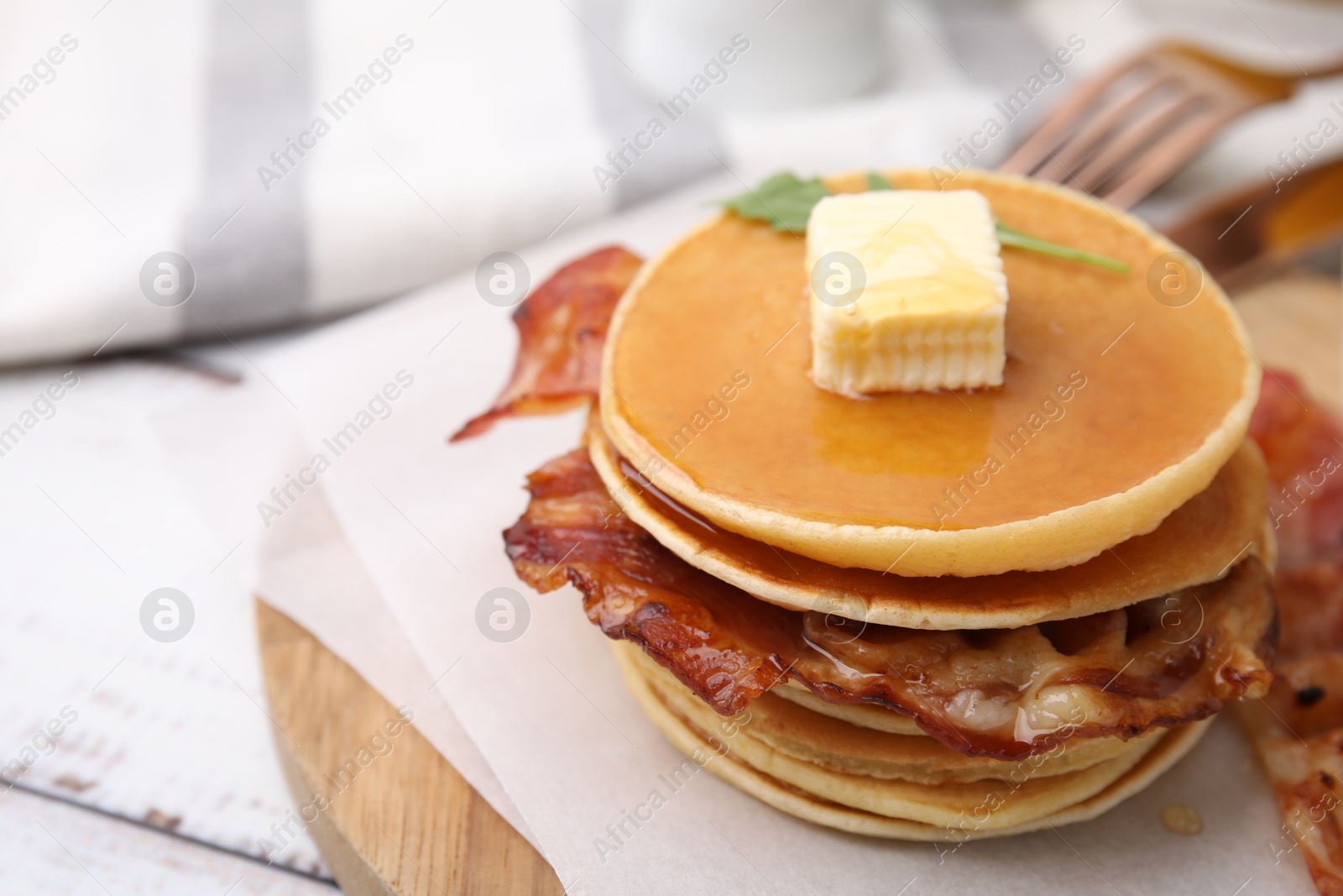Photo of Delicious pancakes with bacon, butter and honey on table, closeup. Space for text