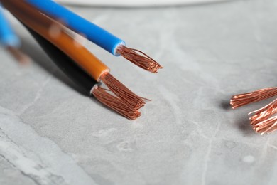 Photo of Colorful electrical wires on gray textured surface, closeup