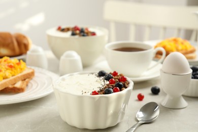 Delicious breakfast with yogurt, granola and berries served on light table