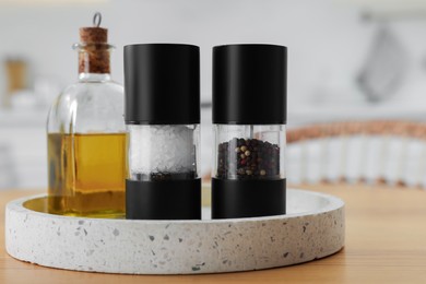 Salt and pepper shakers and bottle of oil on wooden table