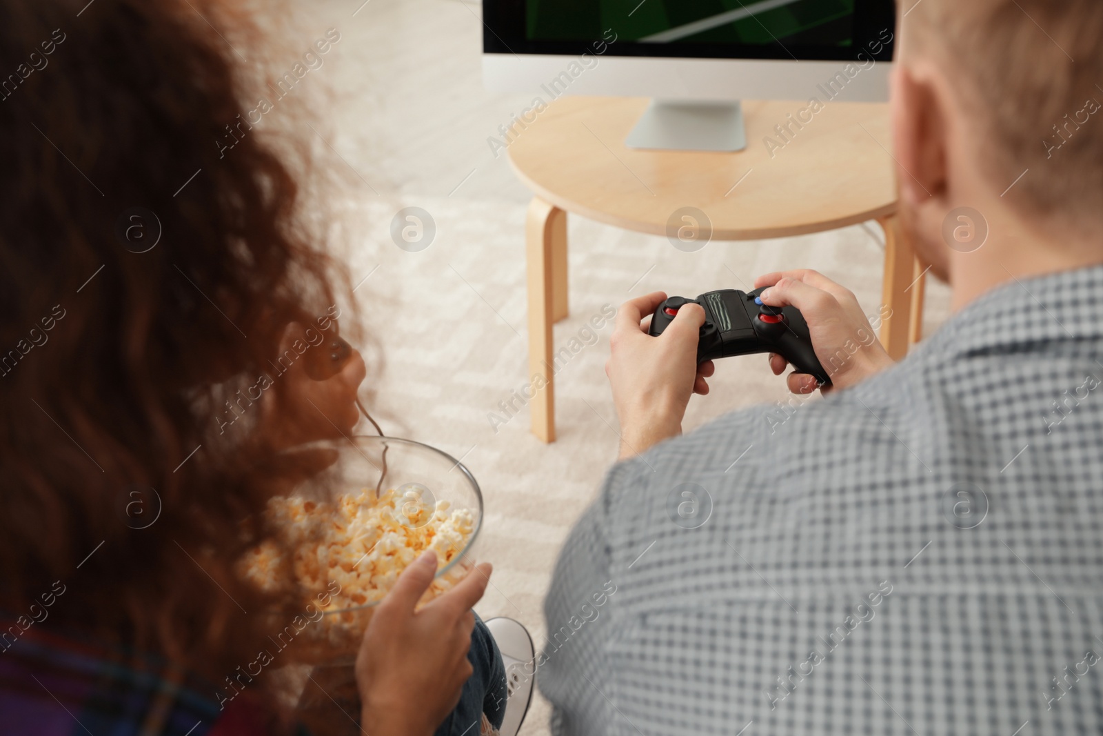 Photo of Young couple playing video games at home, closeup