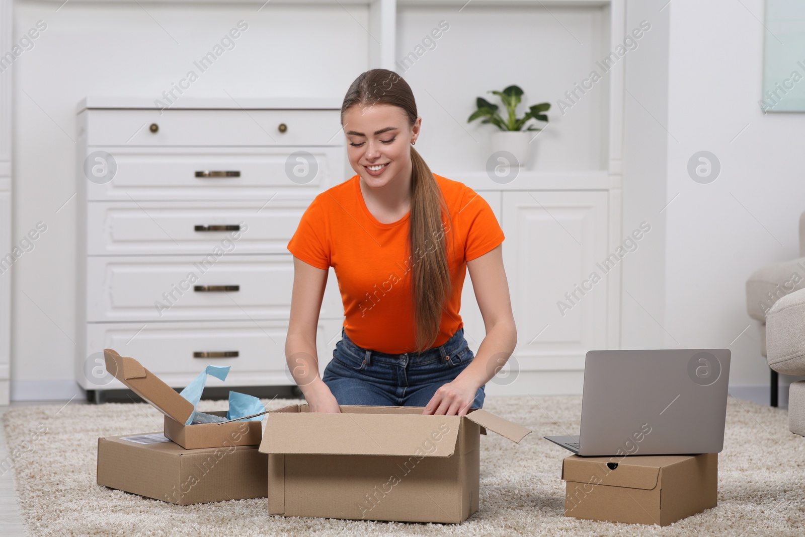 Photo of Happy woman unpacking parcel at home. Online store