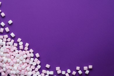 Delicious marshmallows on purple background, flat lay. Space for text