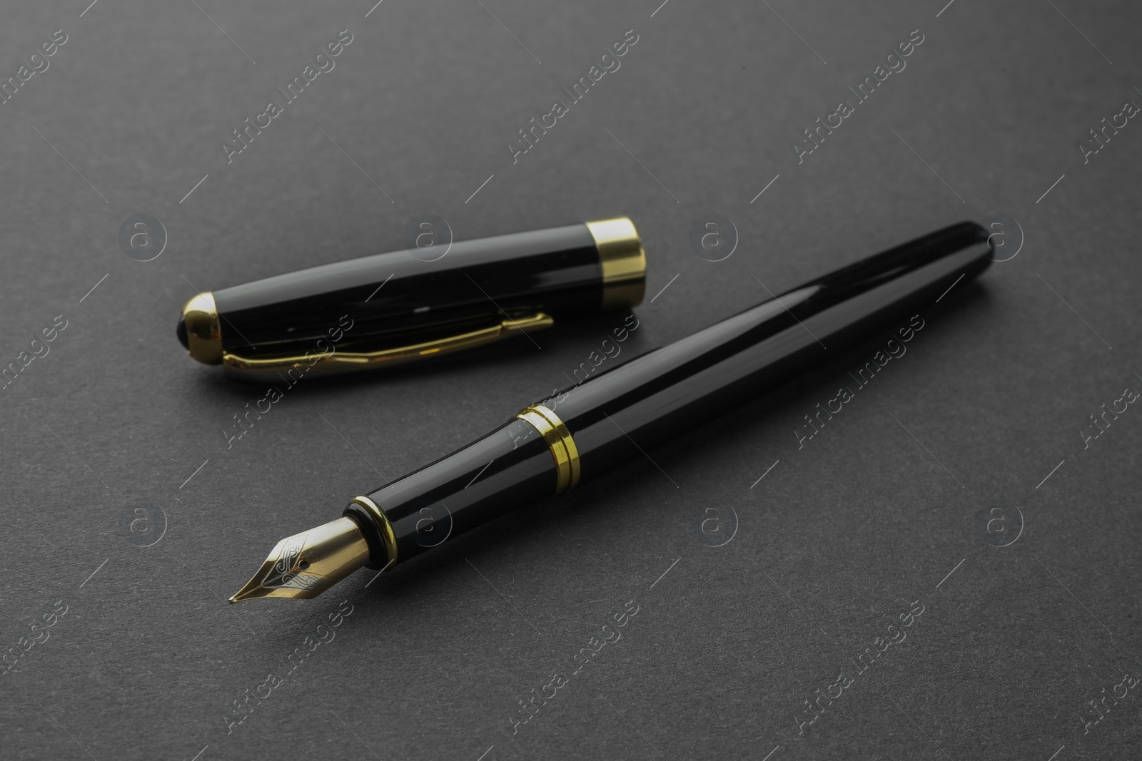 Photo of Stylish fountain pen with cap on black background