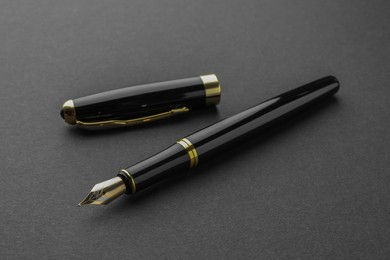 Photo of Stylish fountain pen with cap on black background
