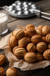 Photo of Bowl of delicious nut shaped cookies on wooden table, closeup