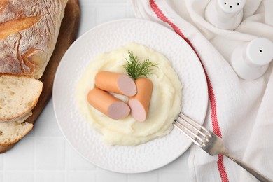 Photo of Delicious boiled sausages and mashed potato on white tiled table, top view