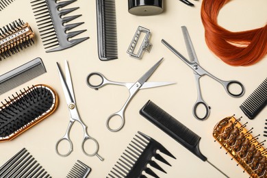 Photo of Flat lay composition of professional scissors, hair strand and other hairdresser's equipment on beige background. Haircut tool