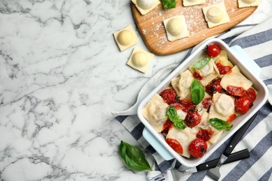 Photo of Raw and cooked ravioli with tomato sauce on white marble table, flat lay. Space for text