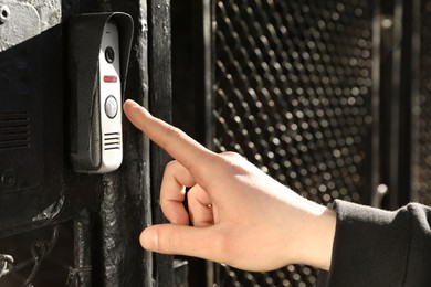 Man ringing intercom with camera near entrance, closeup