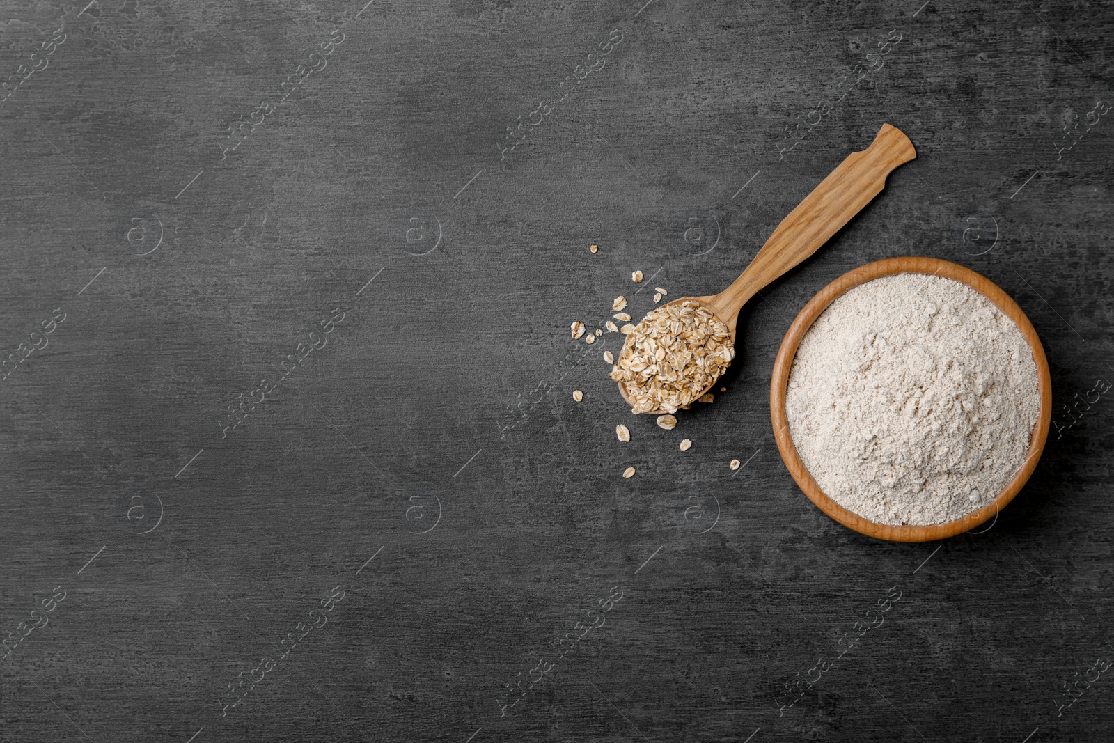 Photo of Bowl with oat flour and flakes in spoon on gray background