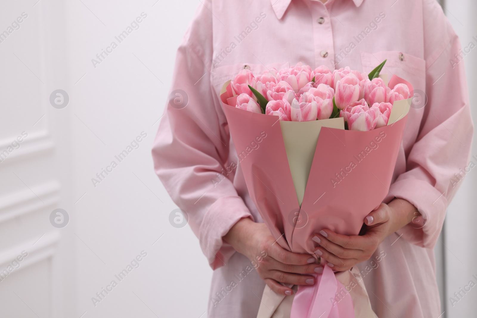 Photo of Woman with bouquet of beautiful fresh tulips on blurred background, closeup