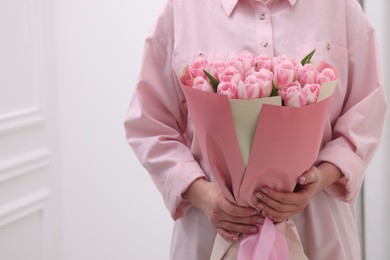 Photo of Woman with bouquet of beautiful fresh tulips on blurred background, closeup