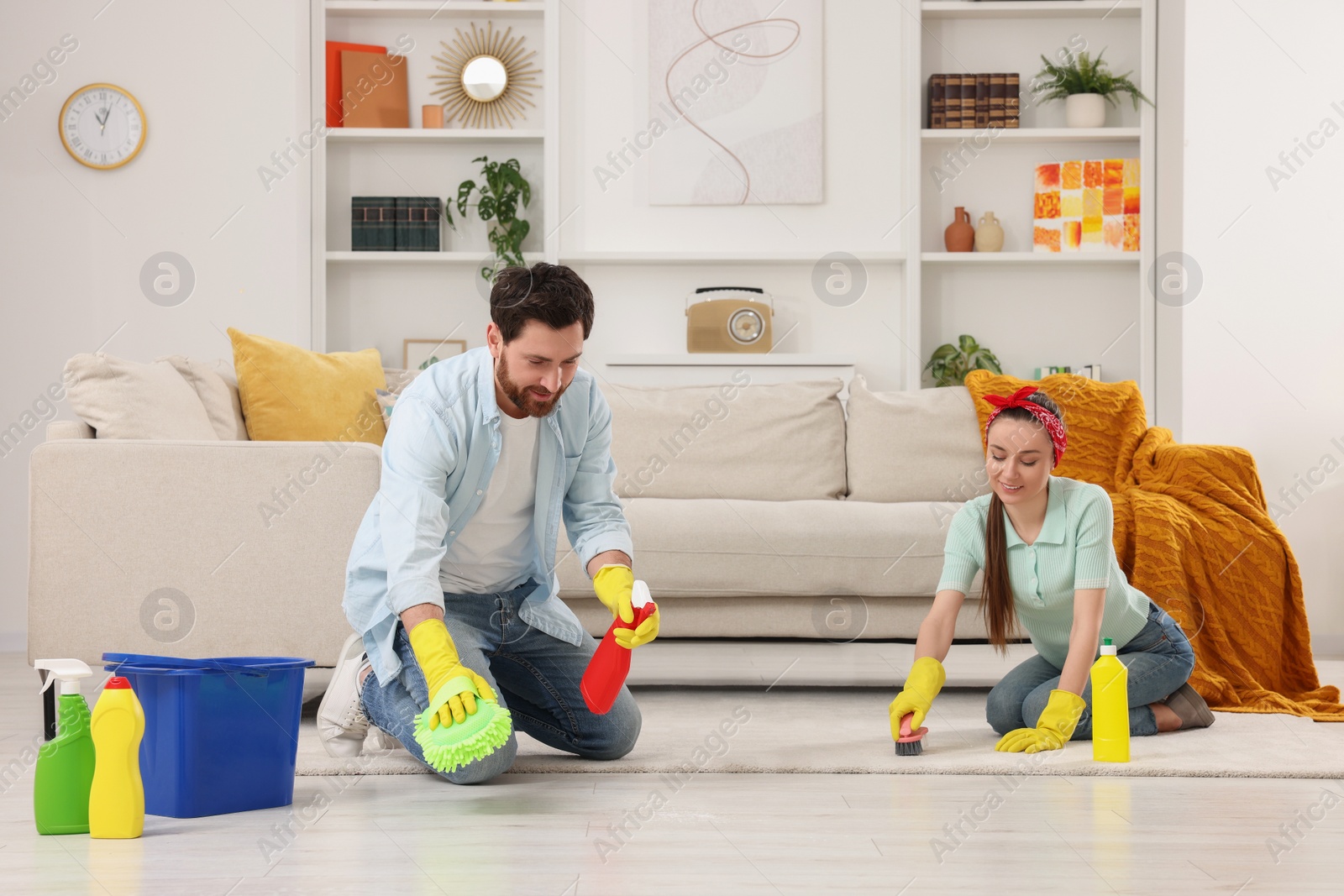 Photo of Spring cleaning. Couple tidying up living room together