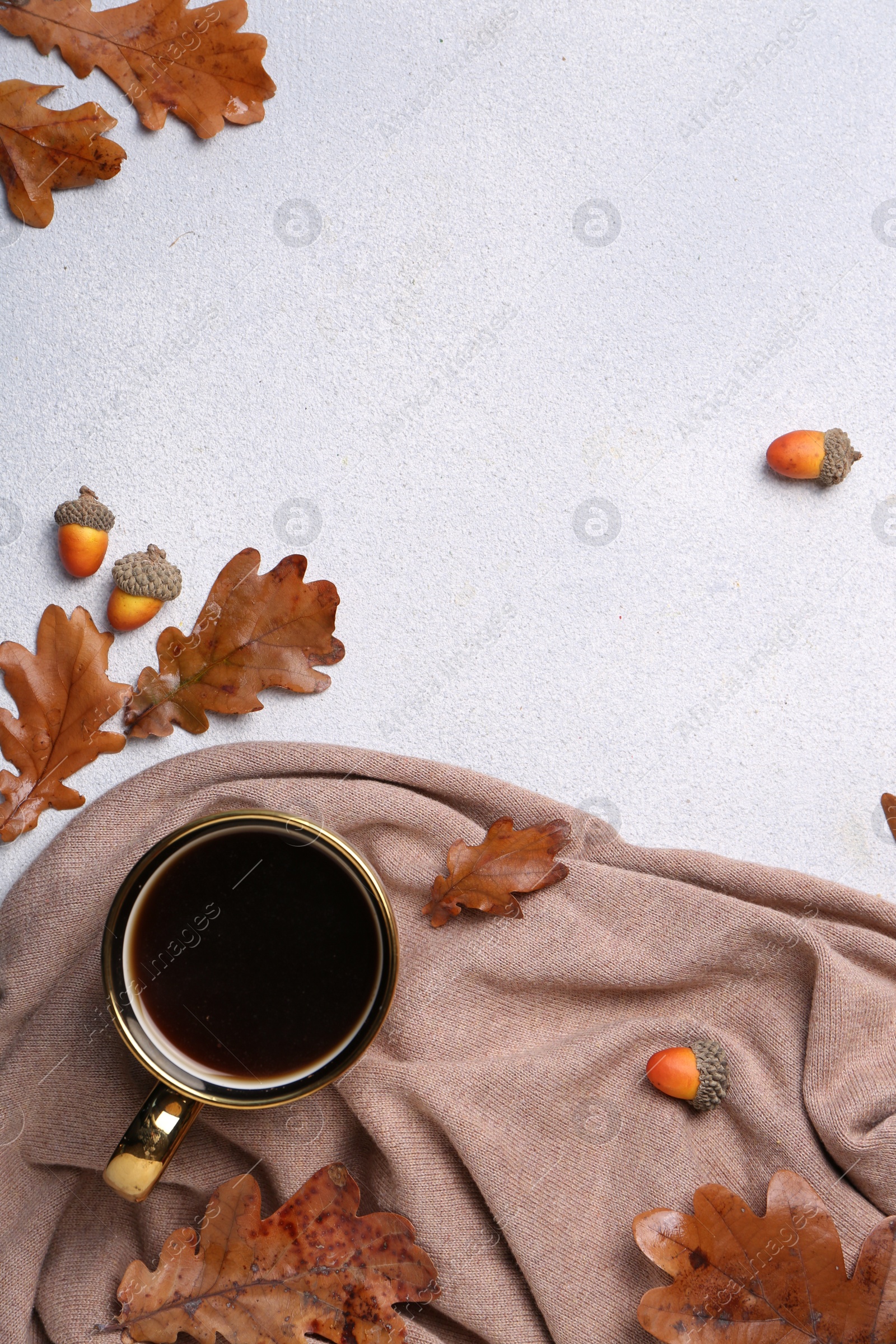 Photo of Flat lay composition with cup of hot drink and autumn leaves on light grey textured table. Space for text