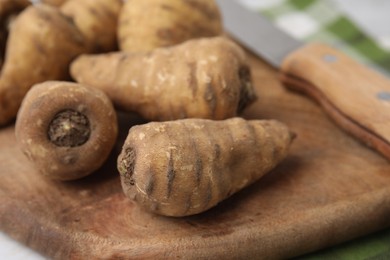 Photo of Tubers of turnip rooted chervil on wooden board, closeup