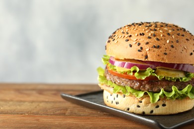 Photo of Burger with delicious patty on wooden table, closeup. Space for text