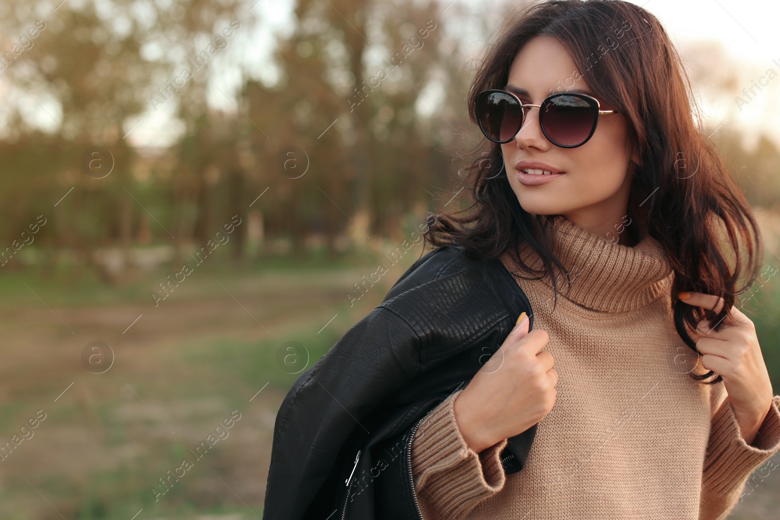 Photo of Beautiful young woman wearing stylish autumn clothes outdoors