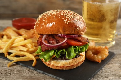 Tasty burger with French fries served on wooden table, closeup. Fast food
