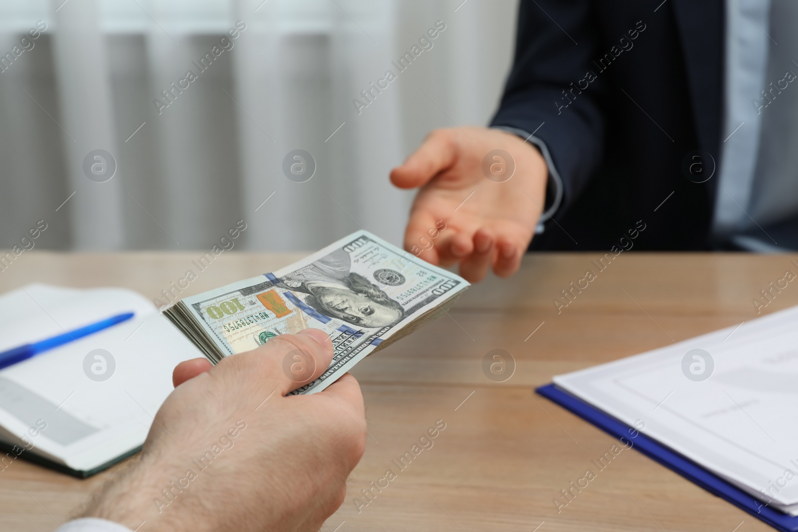 Photo of Cashier giving money to businessman at desk in bank, closeup