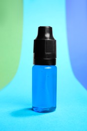 Photo of Bottle with light blue food coloring on bright background