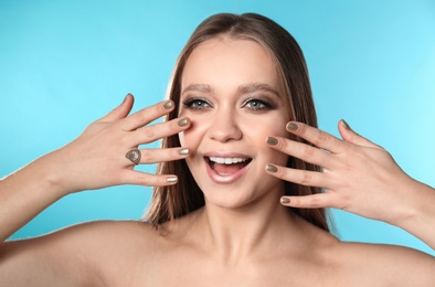 Photo of Beautiful woman with stylish nail polish on color background