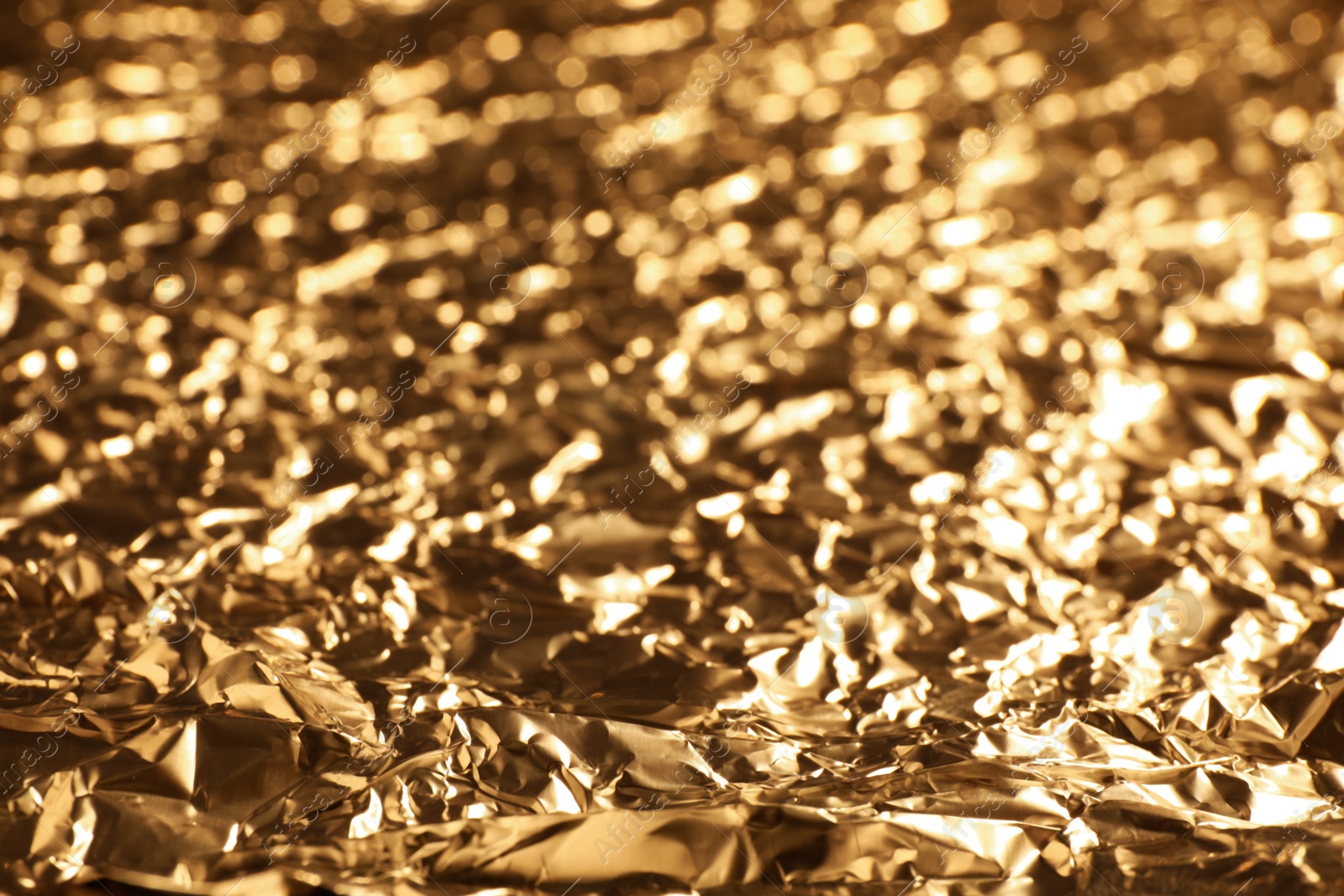 Photo of Crumpled gold foil as background, closeup view