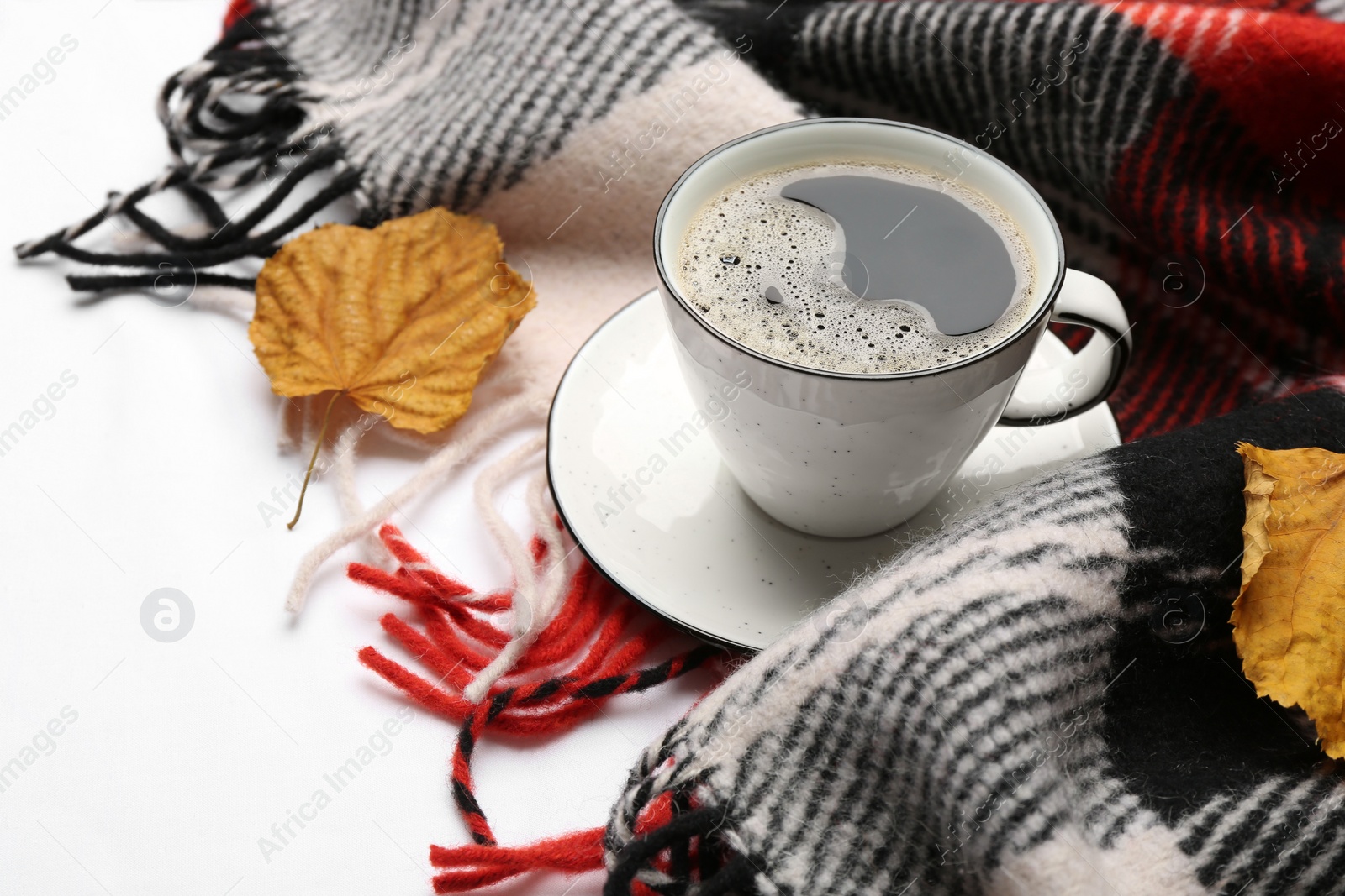 Photo of Composition with hot drink and warm plaid on white bedsheet