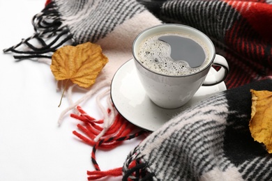 Photo of Composition with hot drink and warm plaid on white bedsheet