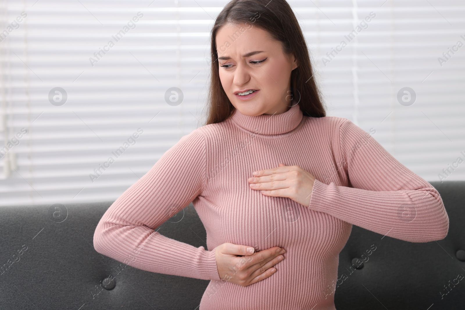 Photo of Mammology. Woman doing breast self-examination at home