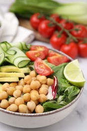 Tasty salad with chickpeas and vegetables on white table, closeup