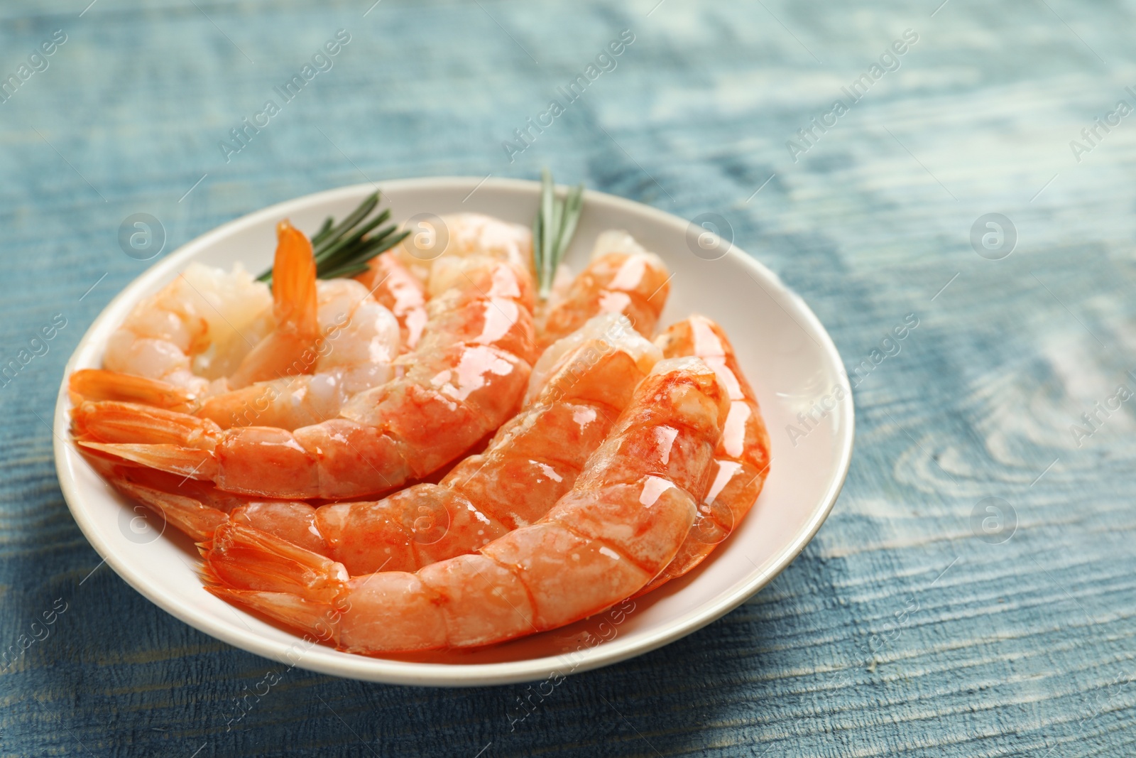 Photo of Plate with delicious shrimps on wooden table