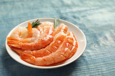 Photo of Plate with delicious shrimps on wooden table