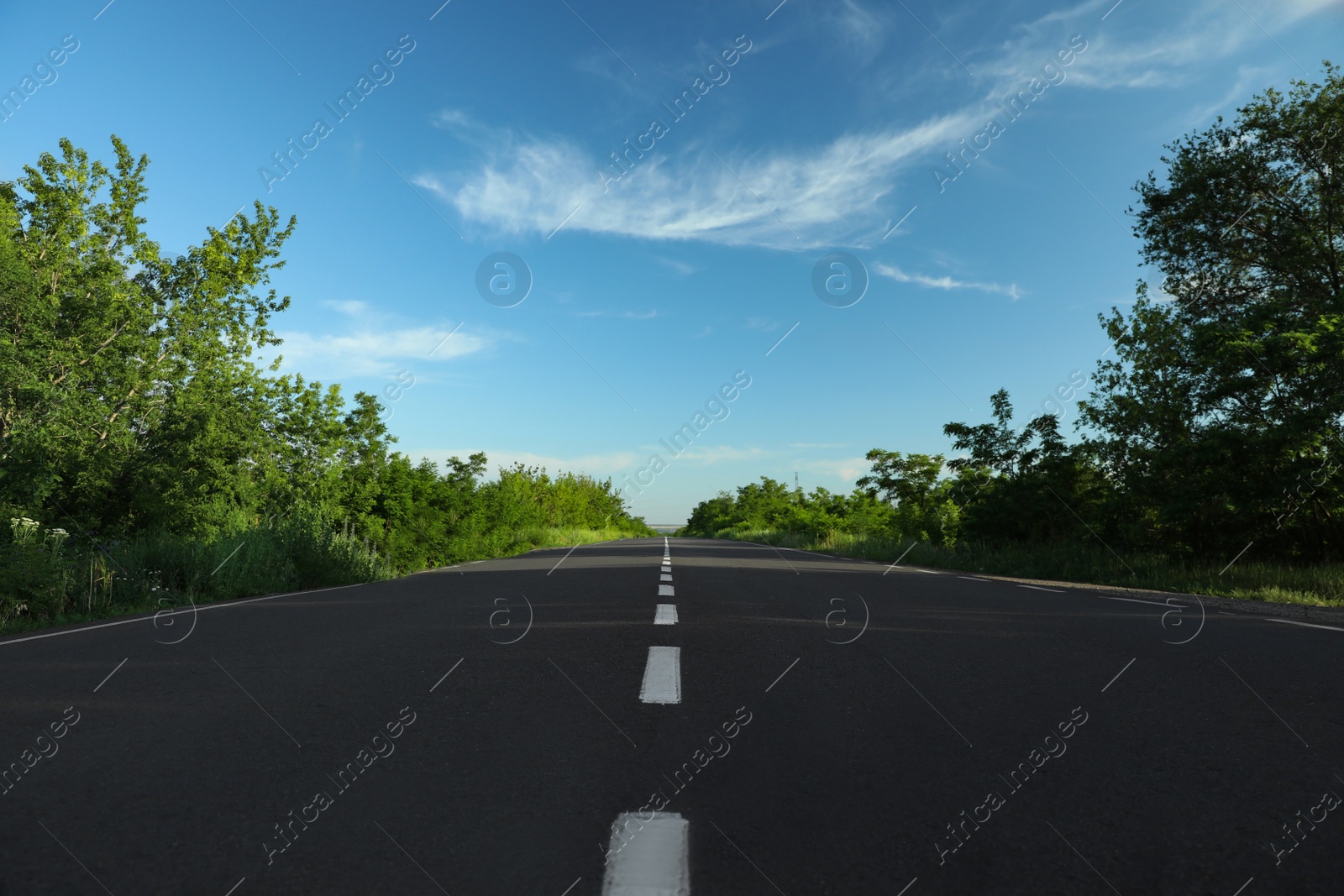 Photo of Asphalt road running through countryside on sunny day