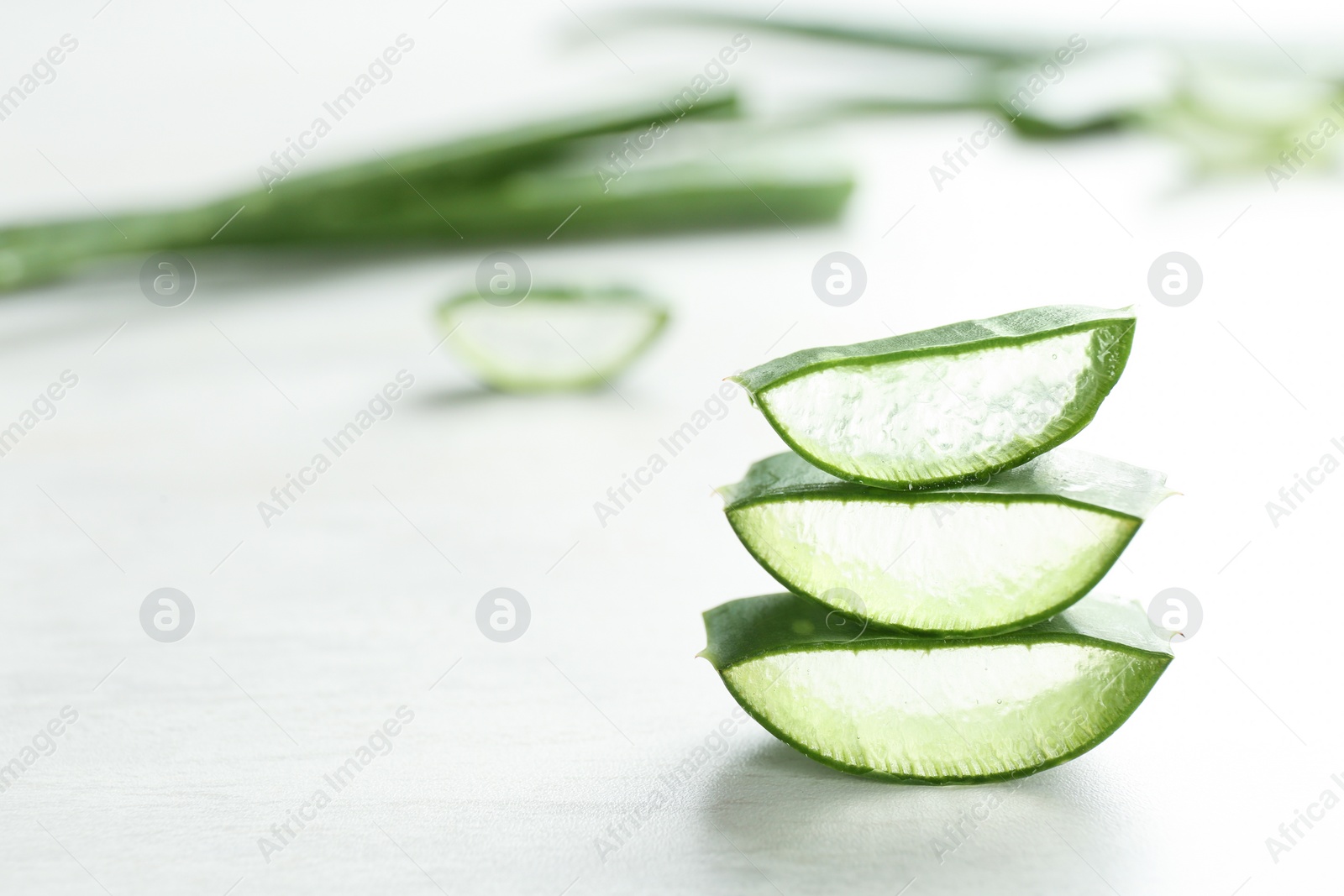 Photo of Slices of aloe vera on light table. Space for text